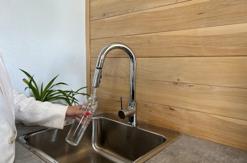 Photo d'une personne qui rempli sa bouteille d'eau au robinet.